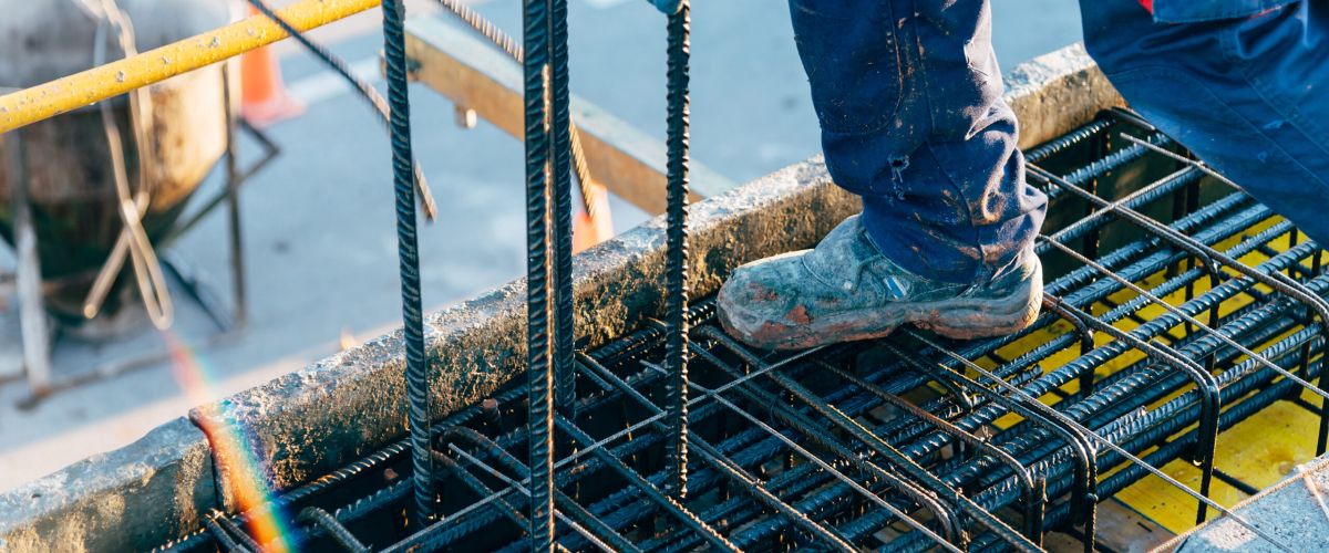 botas de trabajador apoyadas en varillas de encofrado