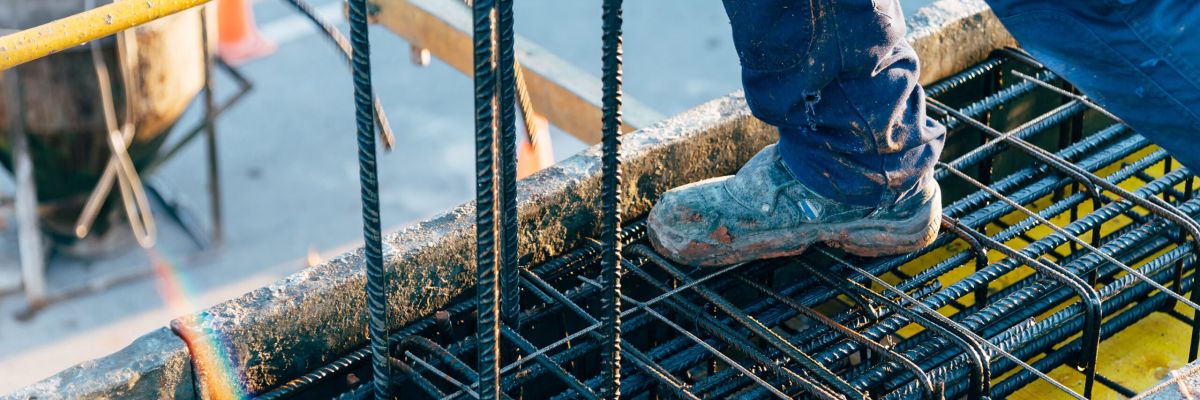 botas de trabajador apoyadas en varillas de encofrado